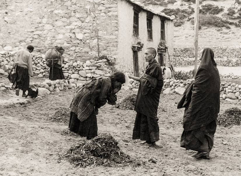 Lama looks on as Rinpoche, the Lawudo Lama, blesses a Sherpa woman on the way to Lawudo, 1969