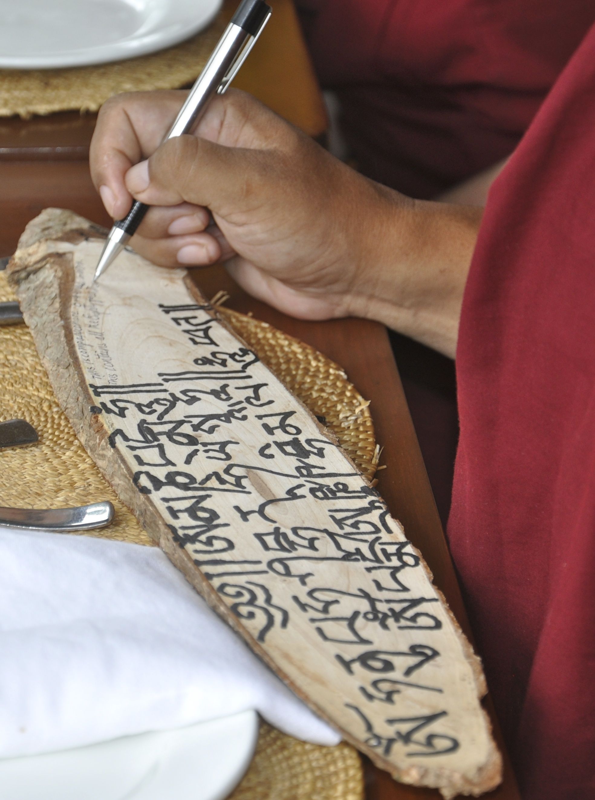Rinpoche writes mantra on a souvenir plaque in Manali, India, 2015. (Photo Thubten Jangchub)